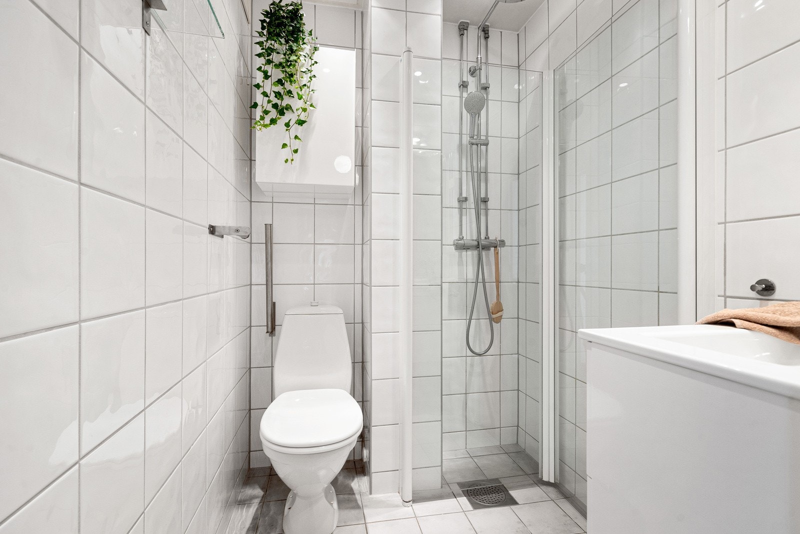 Lyst, flislagt bad med varme i gulv og downlights i himling. Galleribilde