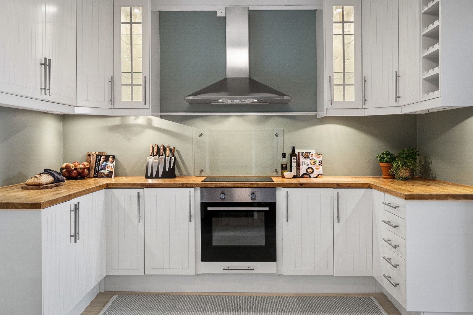 Kjøkkenet utstyrt med integrerte hvitevarer; oppvaskmaskin, stekeovn og nedsenket platetopp, samt vegghengt ventilator med kullfilter. Galleribilde