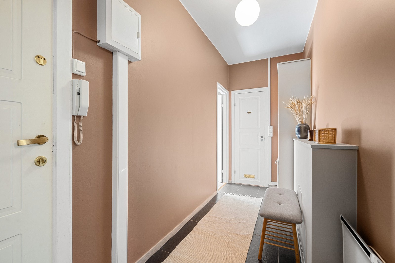 Innbydende entré med flislagt gulv. Det er skyvedørsgarderobe helspeil og god oppbevaringsplass i entré. Galleribilde