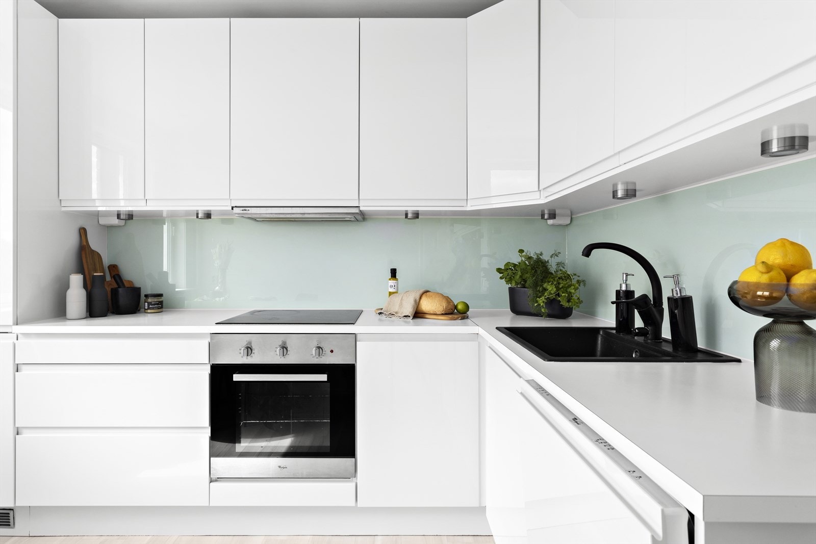 HTH kjøkkeninnredning med hvite glatte fronter, benkeplate i laminat med kum og ettgreps blandebatteri. Galleribilde