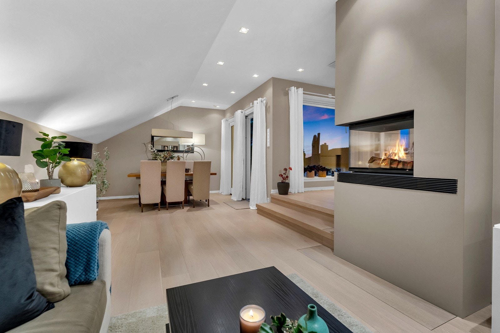 Dessuten er det utgang til terrasse, slik at alt fra kaffekopper til middager og desserter enkelt kan medbringes ut i det fri. Peisen er som et smykke i rommet og sender flammebilde til både kjøkkenet og stuesonene. Galleribilde