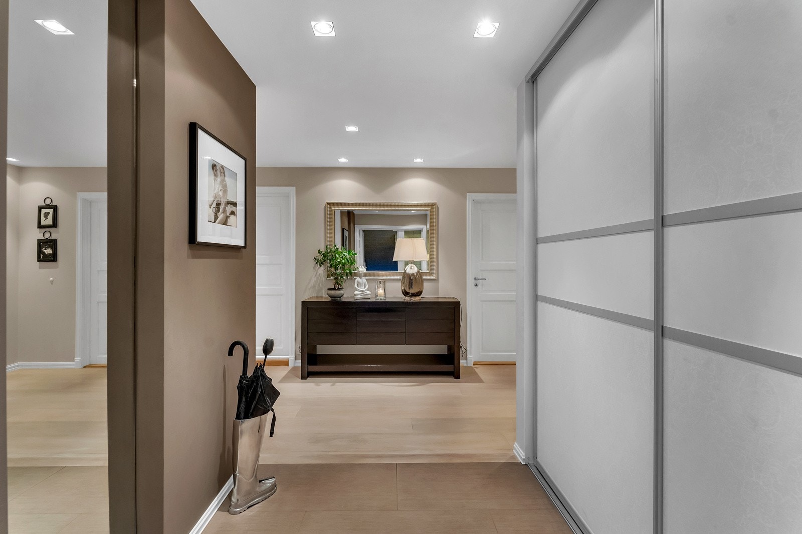 Entreen fremstår som smakfull, som står godt til resten av boligen. Listefri overgang mellom vegger og himling forsterker den moderne stilen. Det er innebygd speil, innfelte spotter i himlingen og en bred skyvedørsgarderobe. Galleribilde