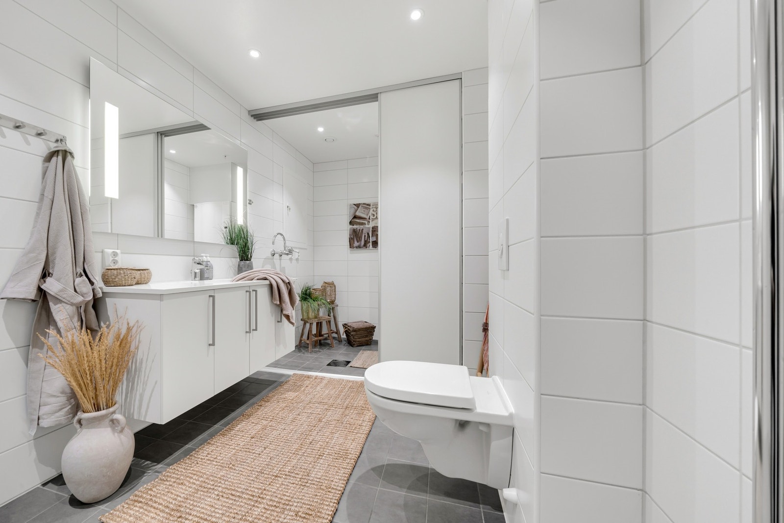 I forlengelse av bad finner man leilighetens praktiske vaskeavdeling, i det daglige skjult bak skyvedører. Galleribilde