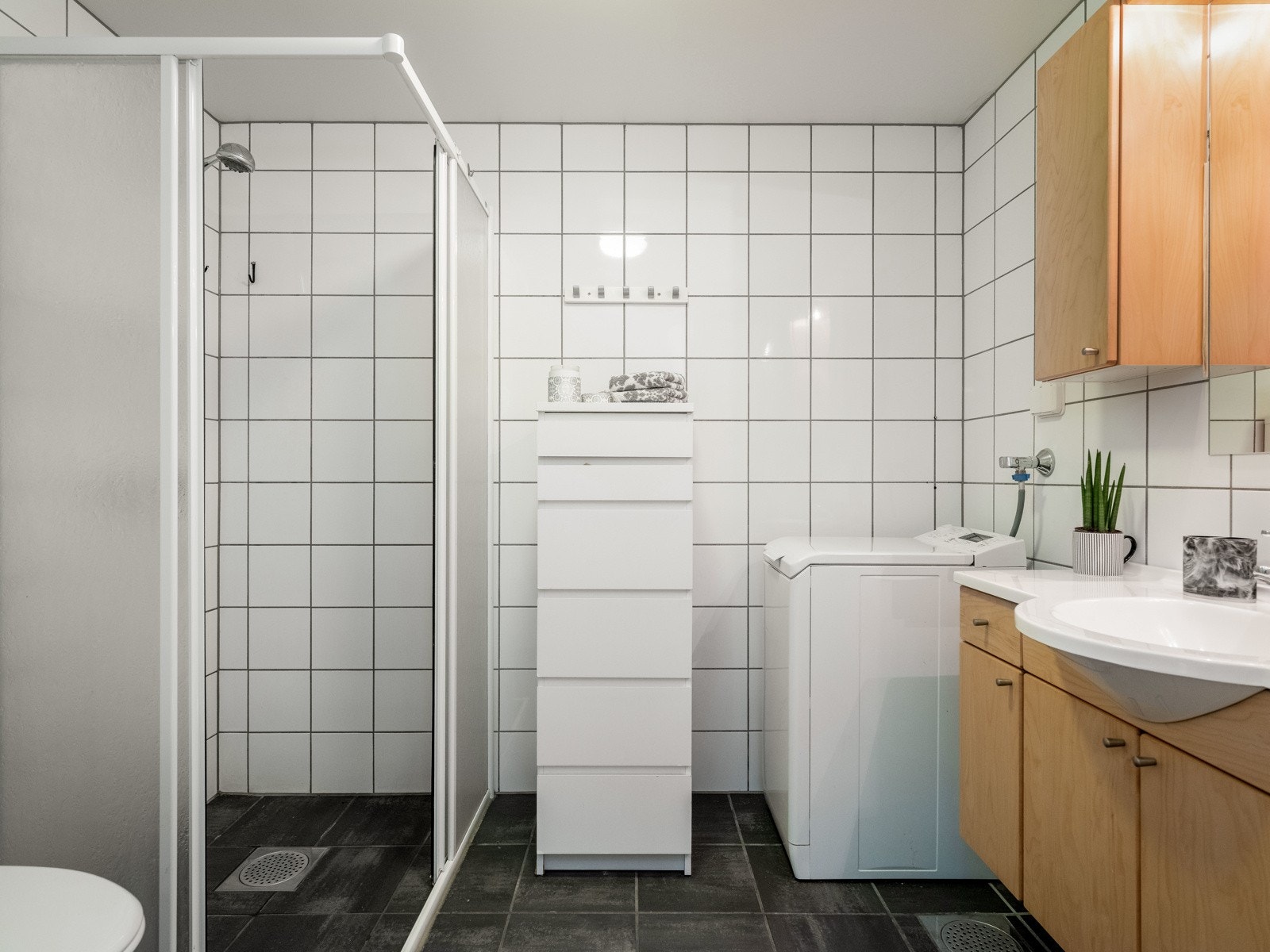Badet er i god bruksmessig stand, og byr på pen dusjsone og praktisk innredning.