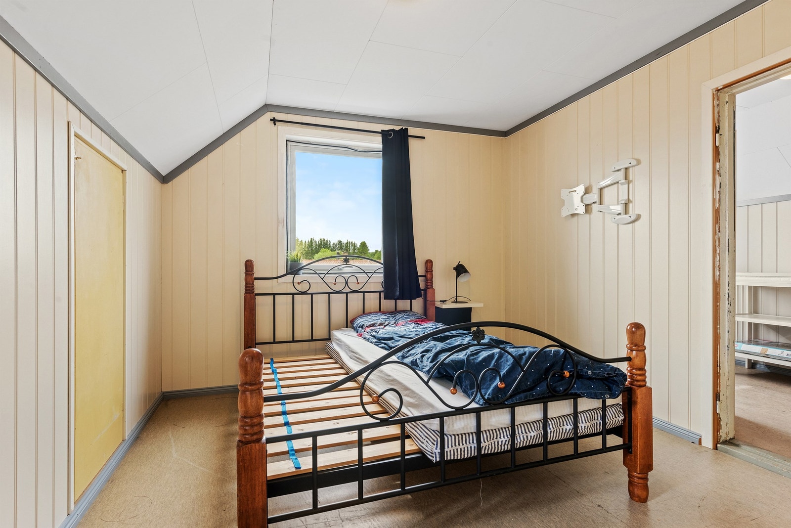 Et annet soverom med gulmalte vegger og belegg på gulvet. Rommet er romslig med adkomst gjennom et annet soverom. Galleribilde