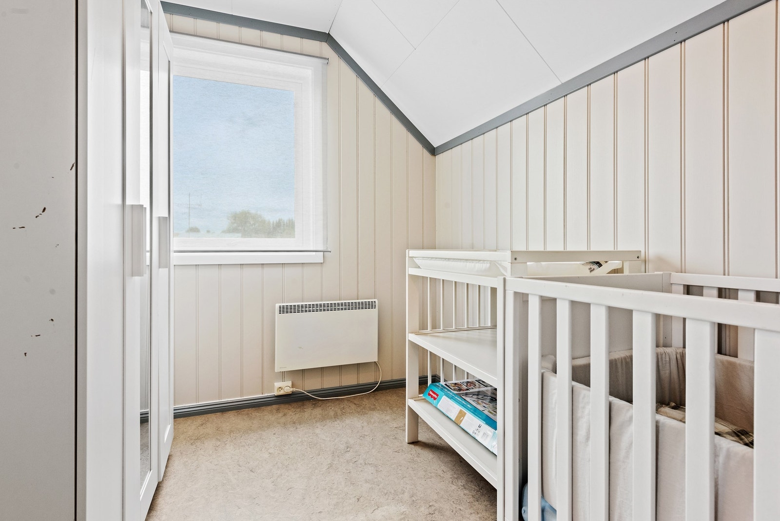 Det tredje soverommet har hvitmalt panel på veggene og lyst spraglete belegg på gulvet. Galleribilde