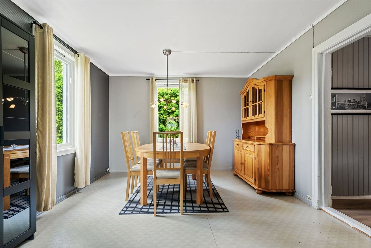 Spisestuen har gråmalte vegger i to nyanser og belegg på gulvet. Galleribilde