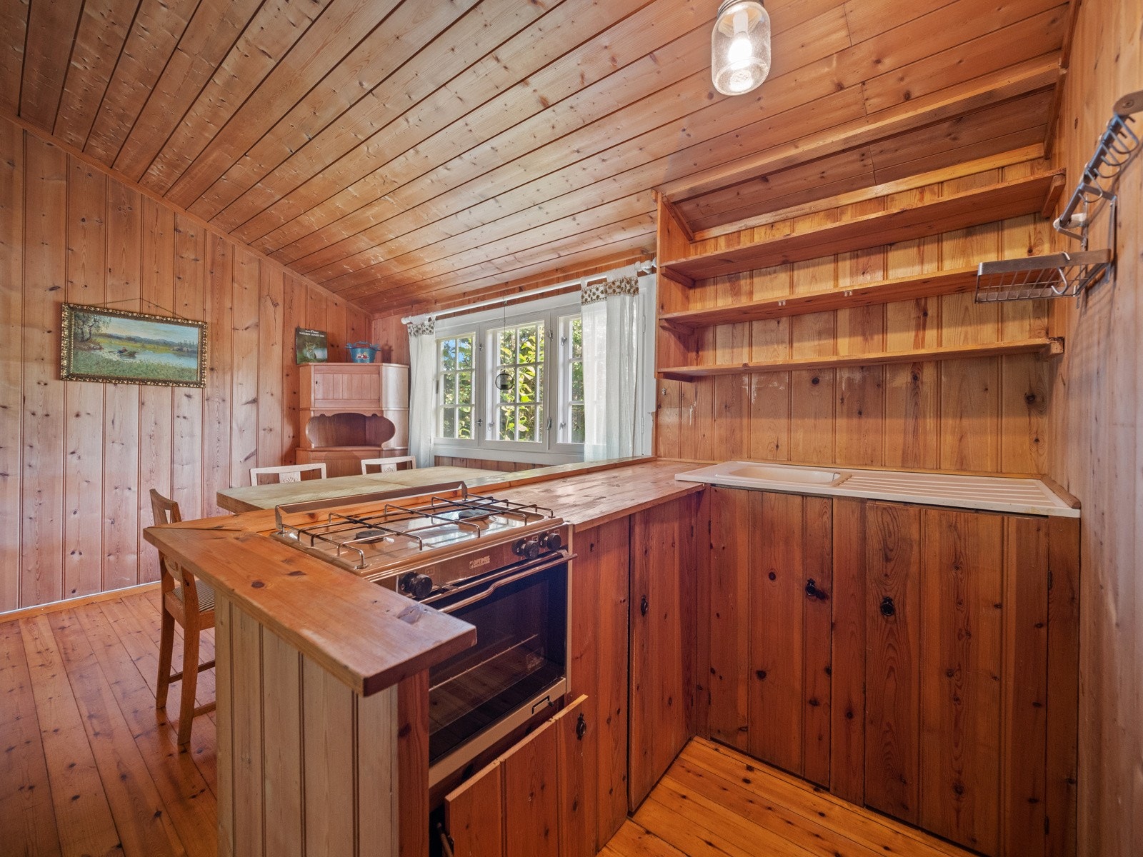 Enkel kjøkkeninnredning med godt med benk- og oppbevaringsplass Galleribilde