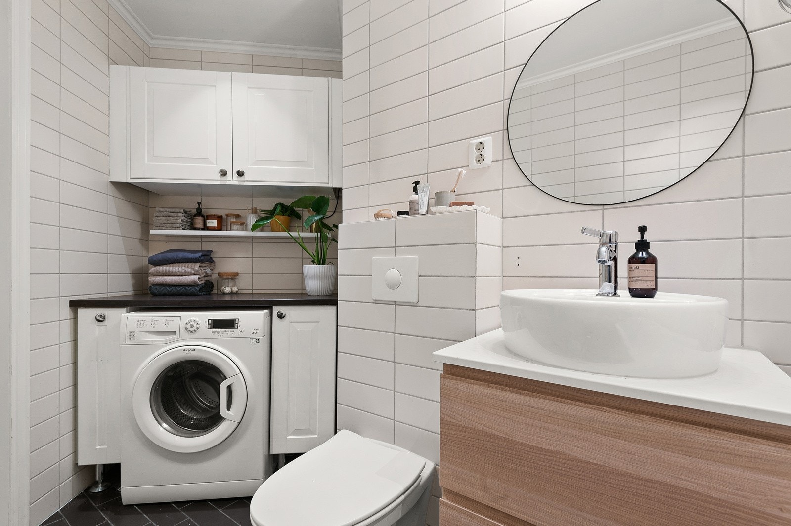 Praktisk med egen vaskesone med plass og opplegg for vaskemaskin under benkeplate, samt oppbevaring i skap og hyller over. Galleribilde