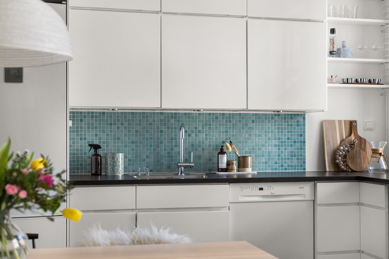 Du har god skap- og benkeplass i innredningen som har hvite glatte fronter og laminert benkeplate med nedfelt oppvaskkum. Både fint og praktisk med mosaikkfliser i benkeryggen ved oppvaskkummen og platetoppen. Galleribilde