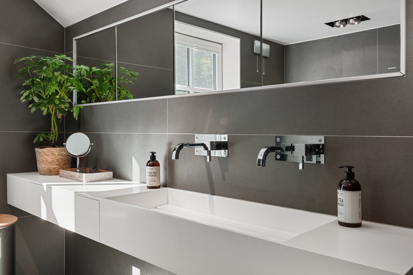 Servant med to stilige innenygde Tapwell armaturer og speilskap fra Antonio Lupi på vegg. Galleribilde