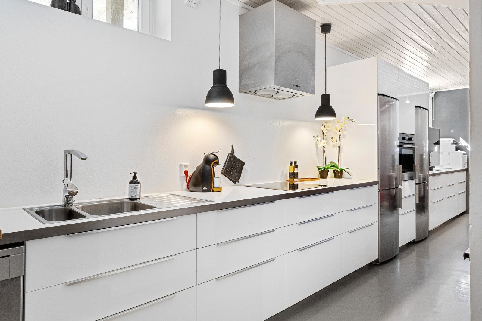 Ikea kjøkkeninnredning i hybeldel med høyglans fronter og laminat benkeplate- Integrerte hvitevarer som induksjonstopp, stekeovn og oppvaskmaskin. Galleribilde