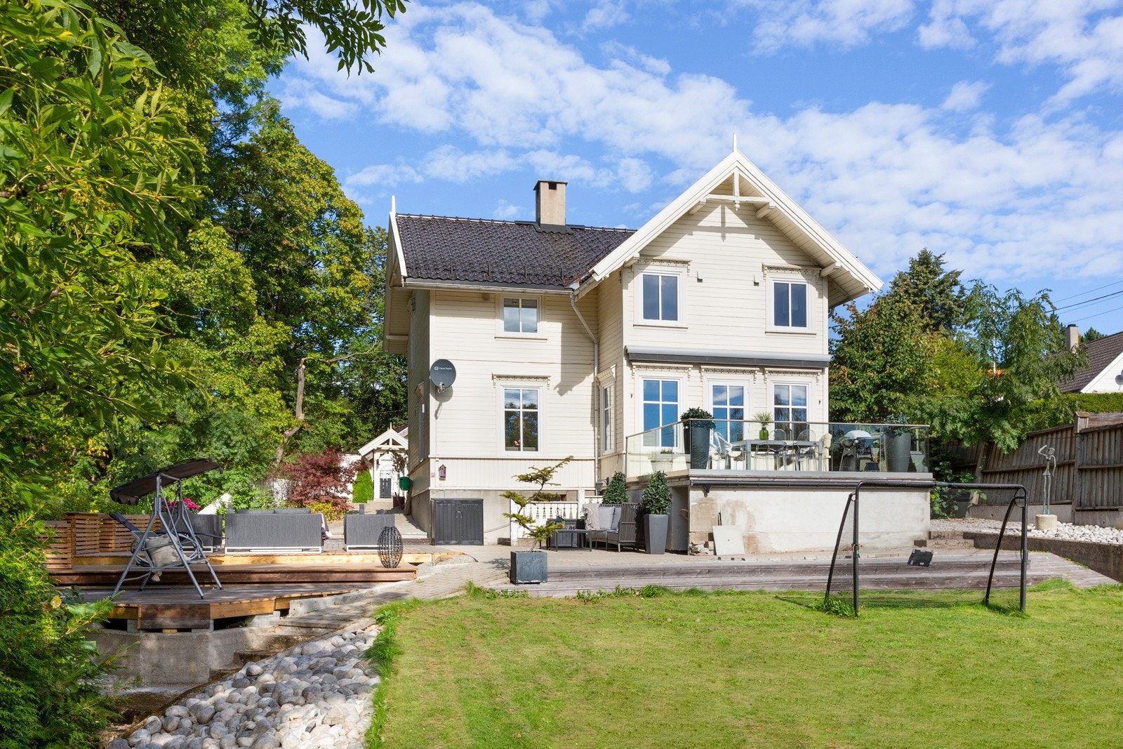 Parkmessig opparbeidet tomt med flott hage på sommerstid. Galleribilde