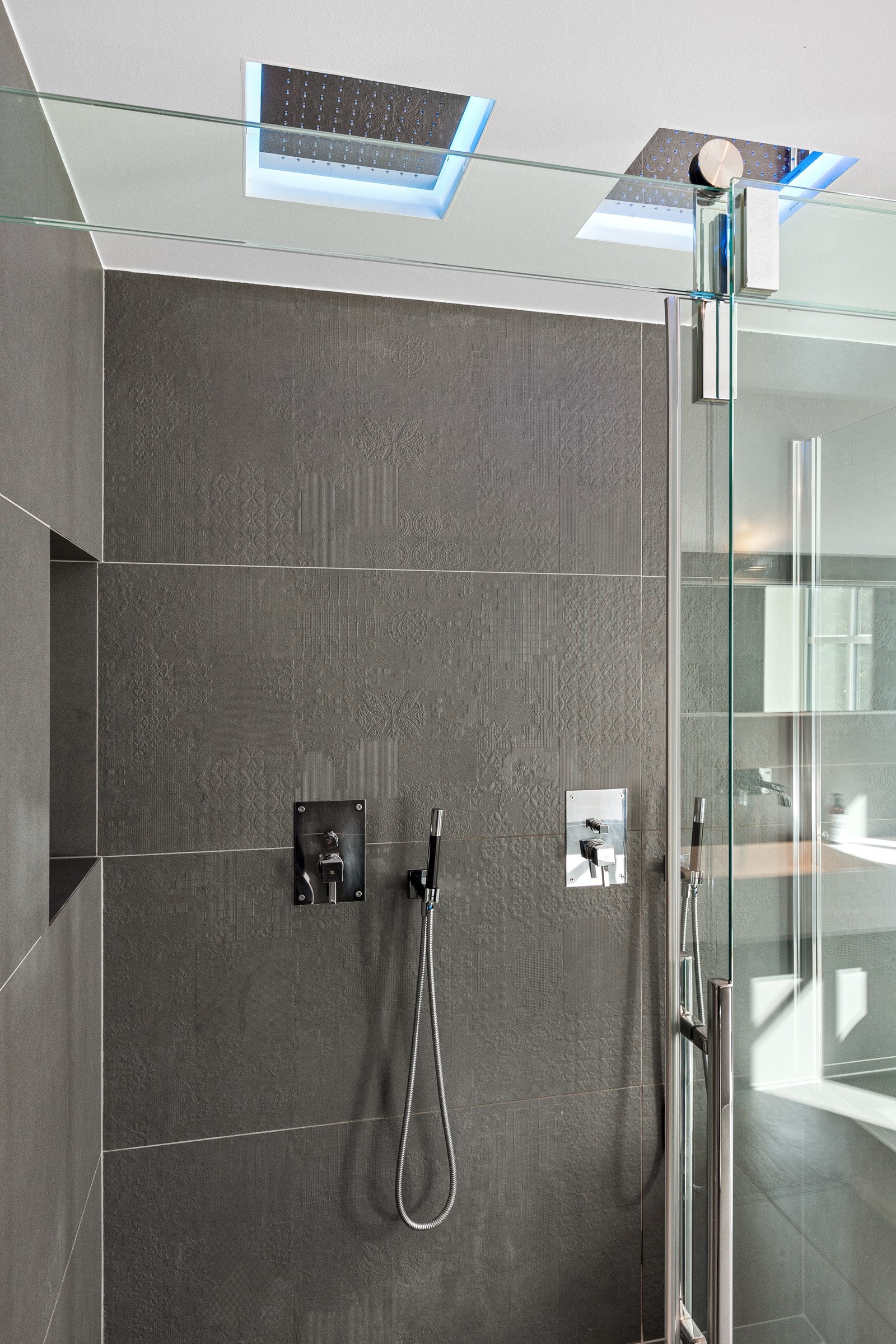Dusjnisje med skyvedører av glass, to innebygde Tapwell armaturer og deilig takdusj fra Antonio Lupi med lys som kan skifte farge, samt hånddusj. Galleribilde