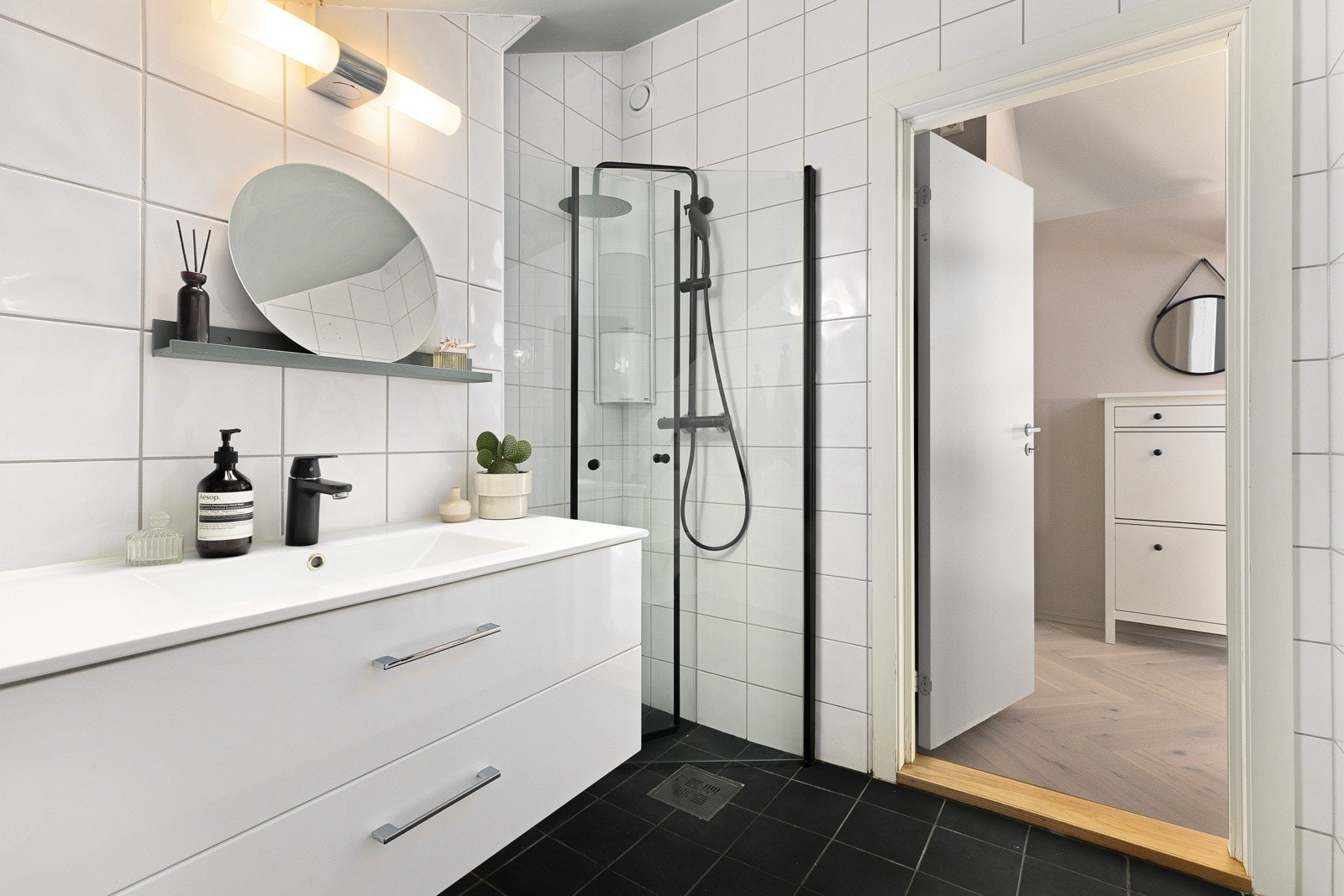 På badet er det gulvmontert klosett, dusjdører, servant med ettgreps blandebatteri og tilhørende servantskap, og opplegg for vaskemaskin. Galleribilde