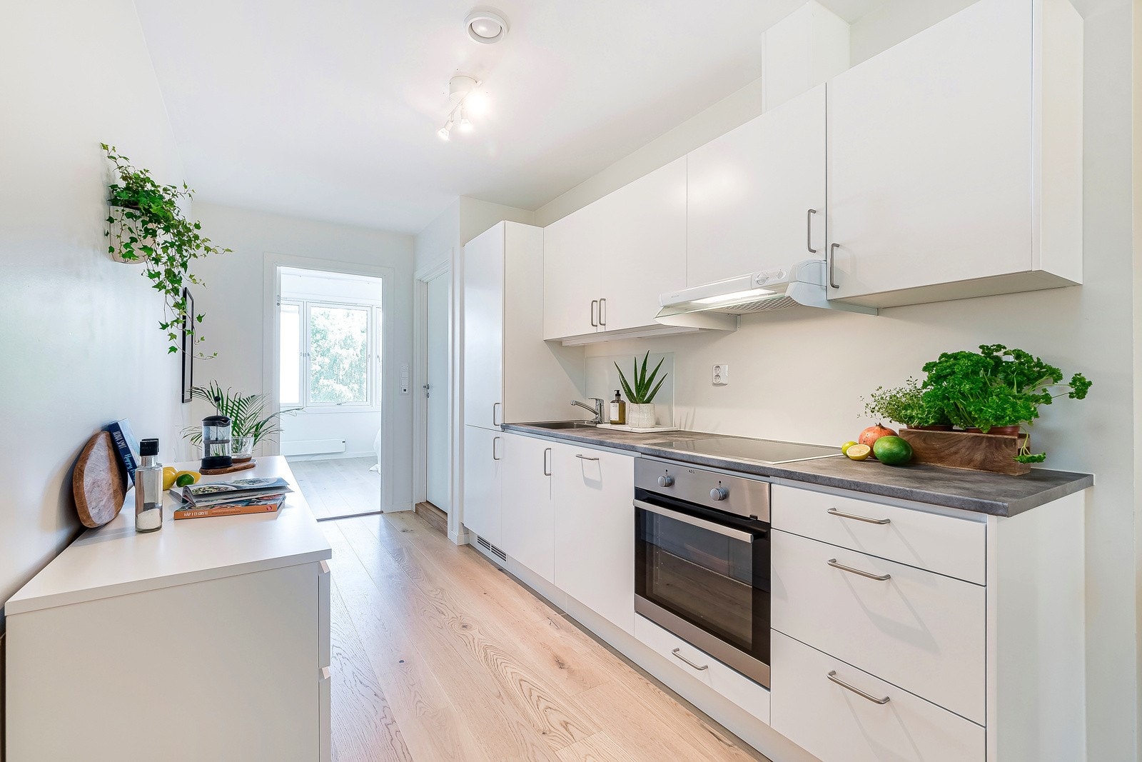 Kjøkkeninnredning fra 2021 med lyse, glatte fronter, laminat benkeplate og nedfelt rustfri oppvaskkum samt ettgreps kjøkkenbatteri. Galleribilde