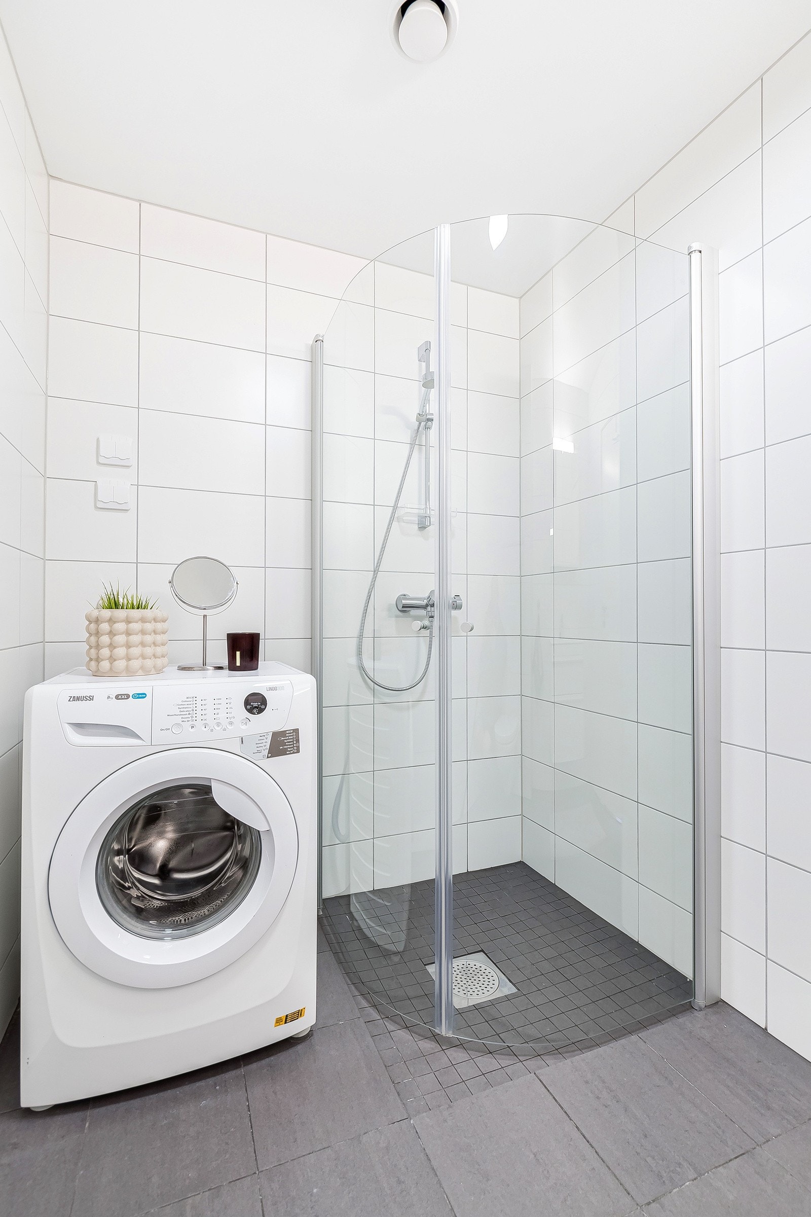 Badet er utstyrt med vegghengt toalett, servant, dusjhjørne og opplegg for vaskemaskin og tørketrommel. Galleribilde