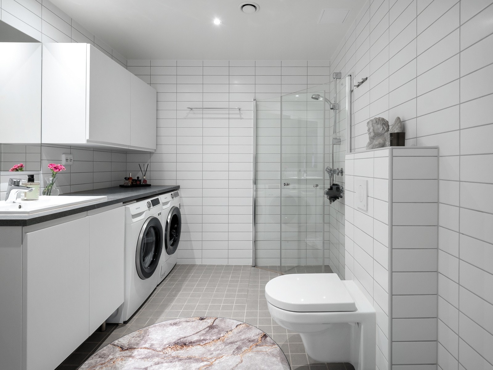 Lekkert, flislagt bad med deilige varmekabler i gulv. Det er plass til både vaskemaskin og tørketrommel under benkeplate. Galleribilde