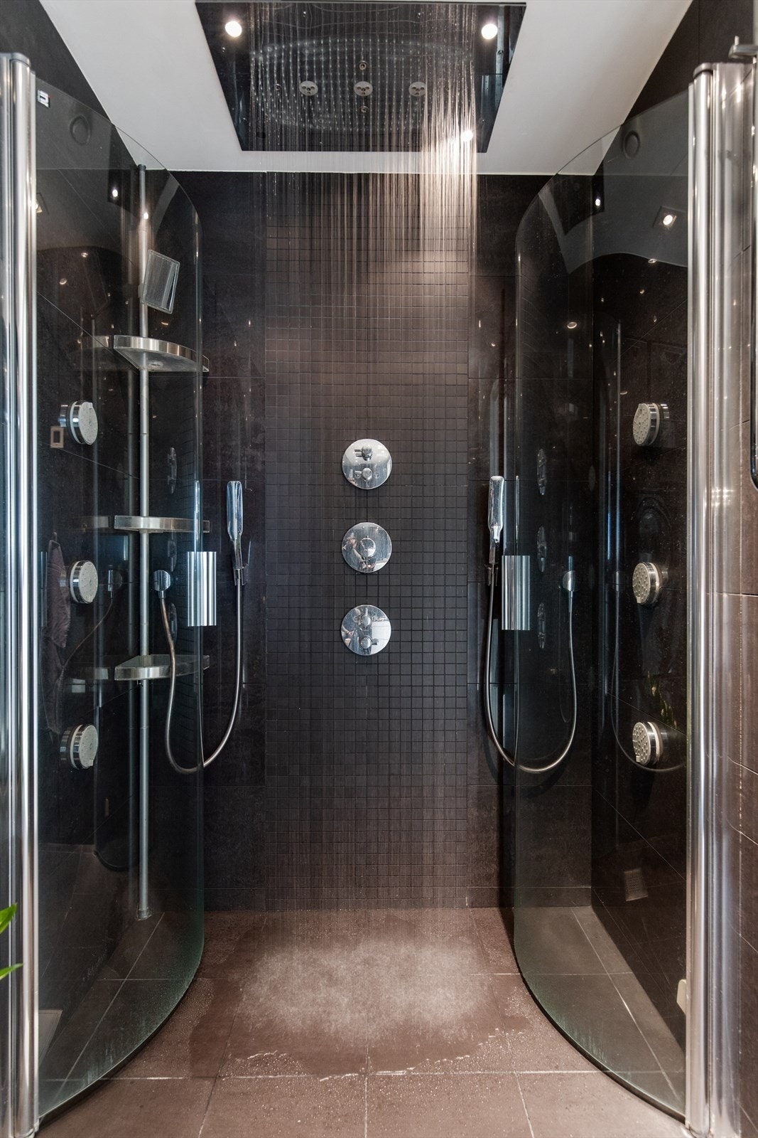 Badet er innredet med vegghengt toalett, servantinnredning, stort speil, dusjnisje med innfeltbare glassdører og takdusj samt opplegg for vaskemaskin. Galleribilde