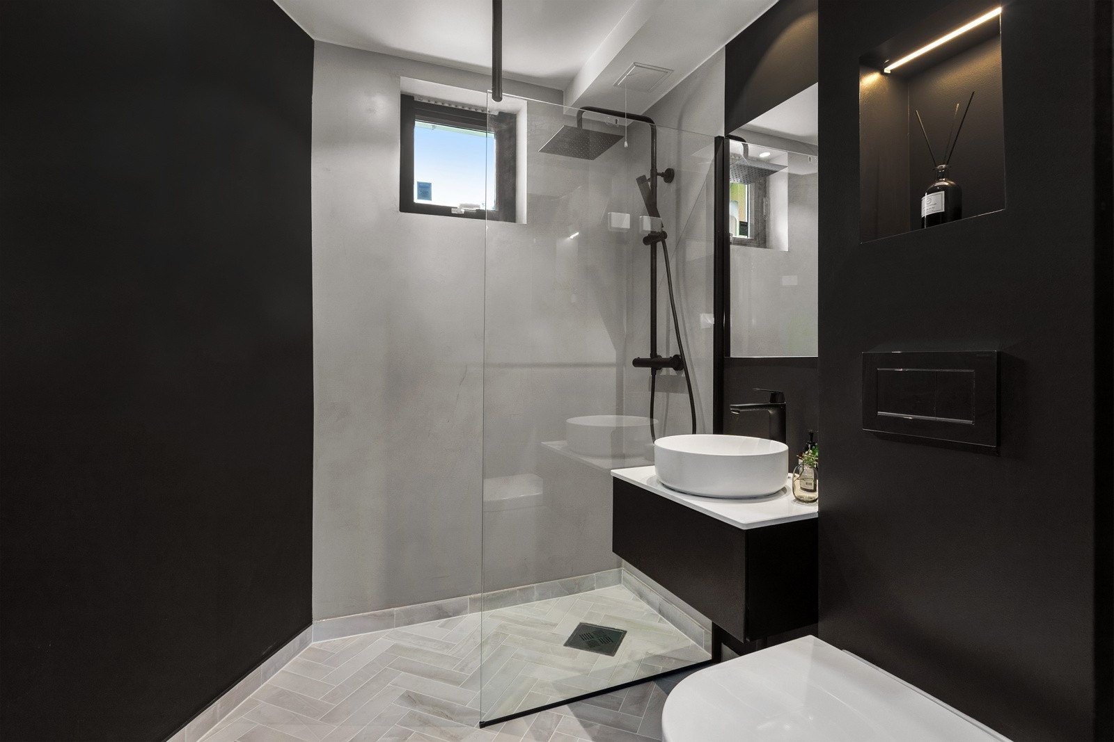 Lekkert oppusset bad med microsement i dusj, servant, og vegghengt WC. Galleribilde