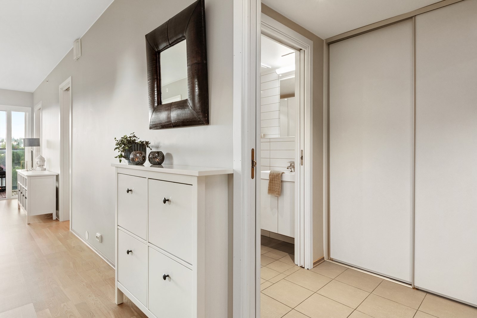 Innbydende entrè med god plass til oppbevaring i skyvedørsgarderobe. Her er det opplegg for vaskemaskin og tørketrommel. Galleribilde