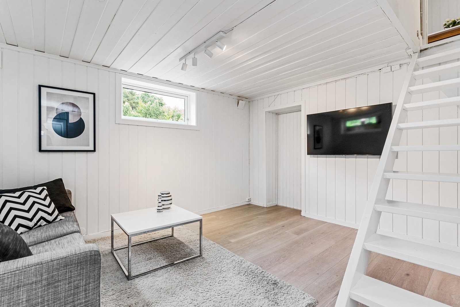 Kjellestuen inneholder sofa, vegghengt TV og sofabord. Perfekt for sosiale sammenkomster og filmkvelder. Galleribilde