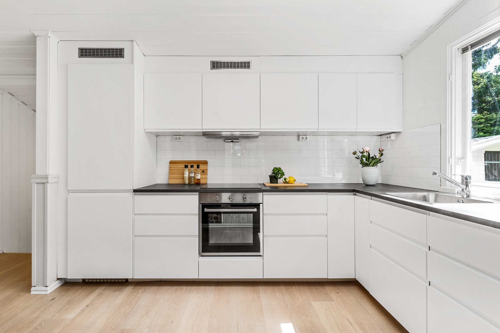 Kjøkkeninnredning fra IKEA med integrerte hvitevarer inkludert oppvaskmaskin. Galleribilde