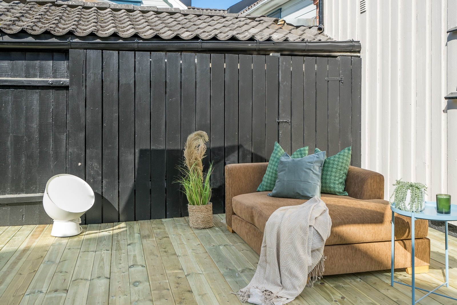 Platting med soffa og bord i bakgården. Galleribilde