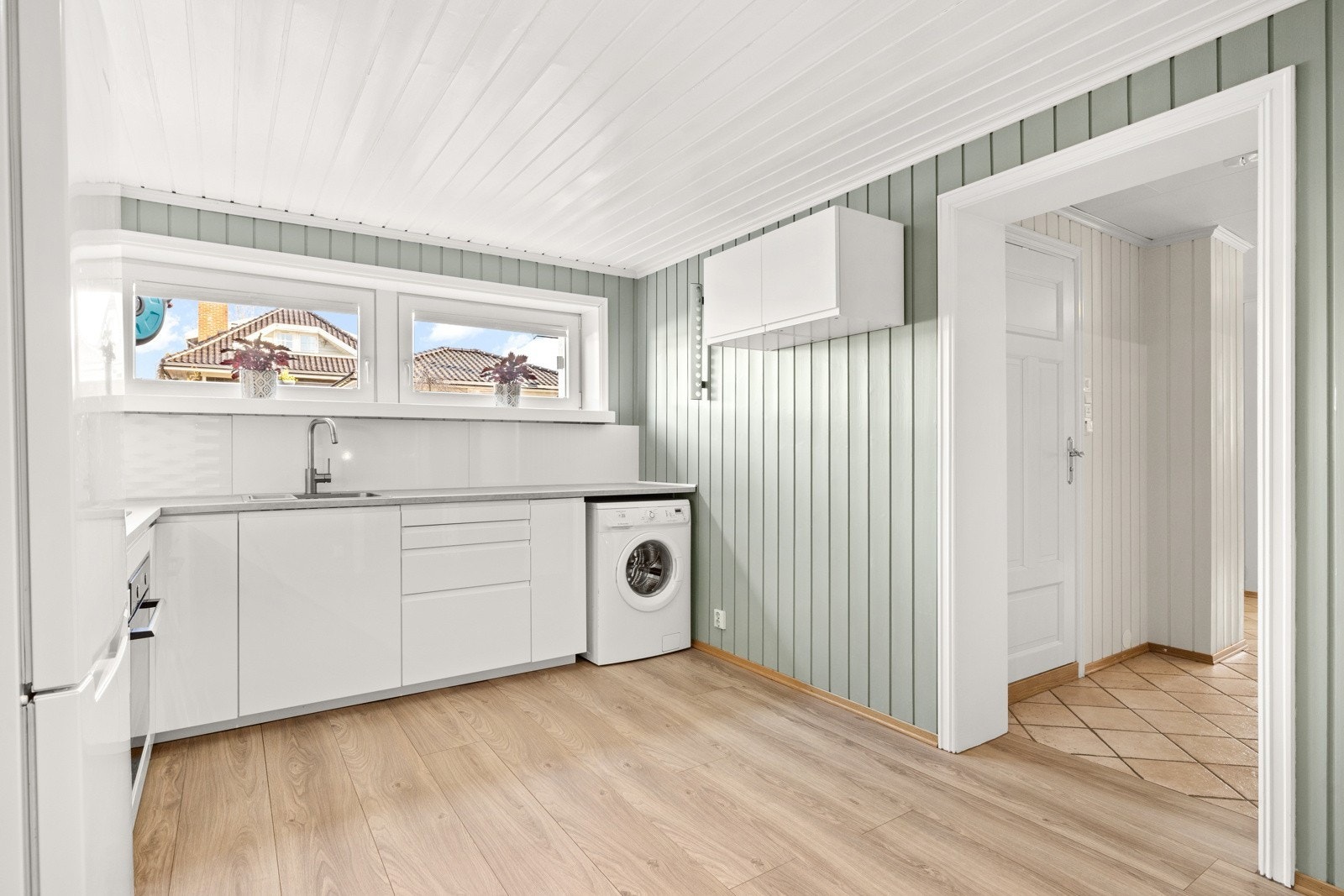 Åpen kjøkken og stue løsning. Vinduer mot gårdsplass. Morgensol. Galleribilde