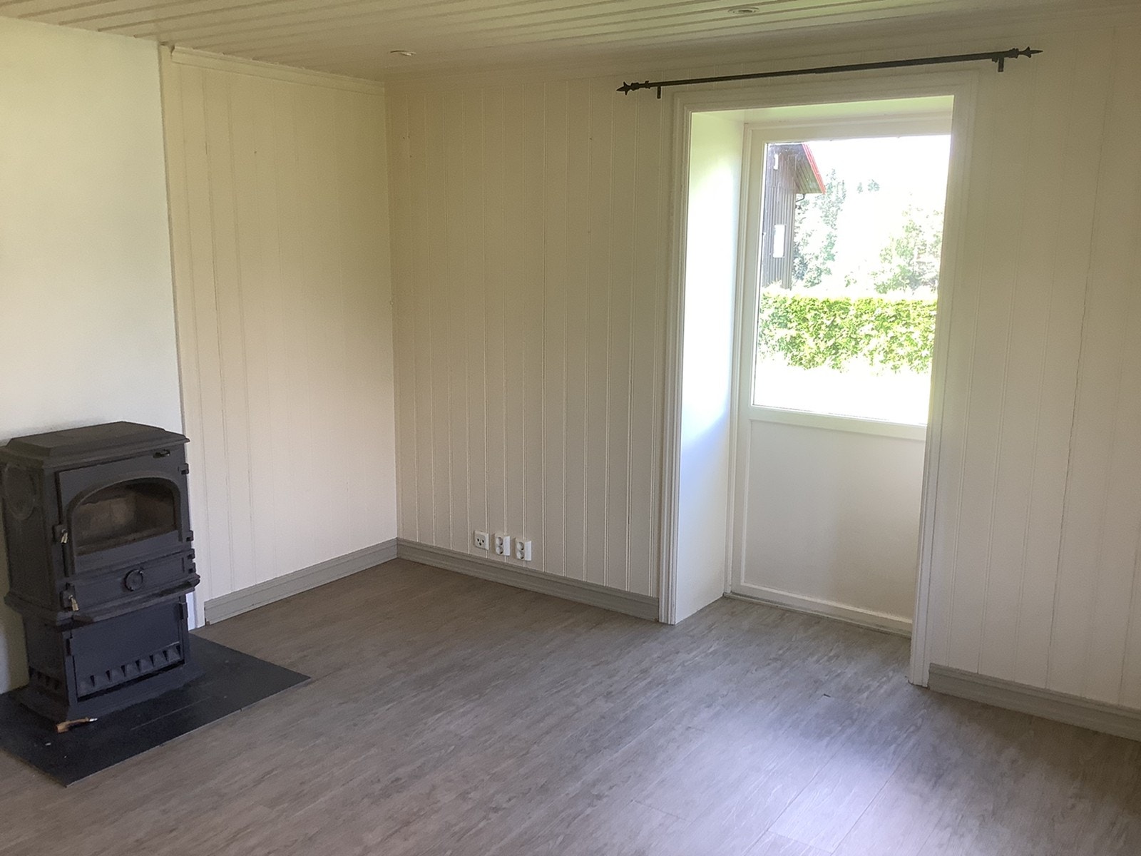 Stue med vedovn og utgang til hage Galleribilde