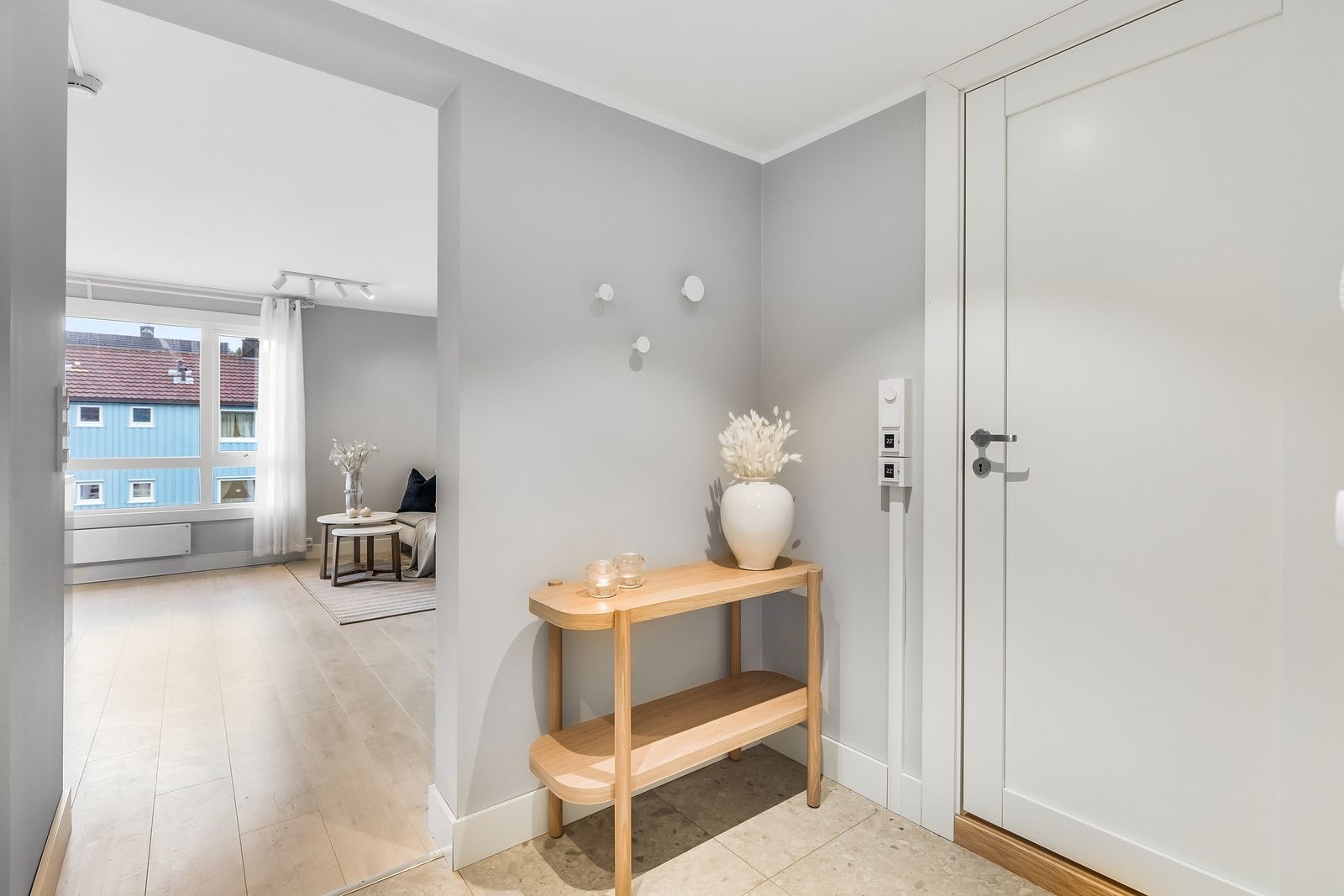 Leilighetens gang er flislagt med varmekabler i gulv. Her er det garderobeskap og inngang til praktisk kott Galleribilde