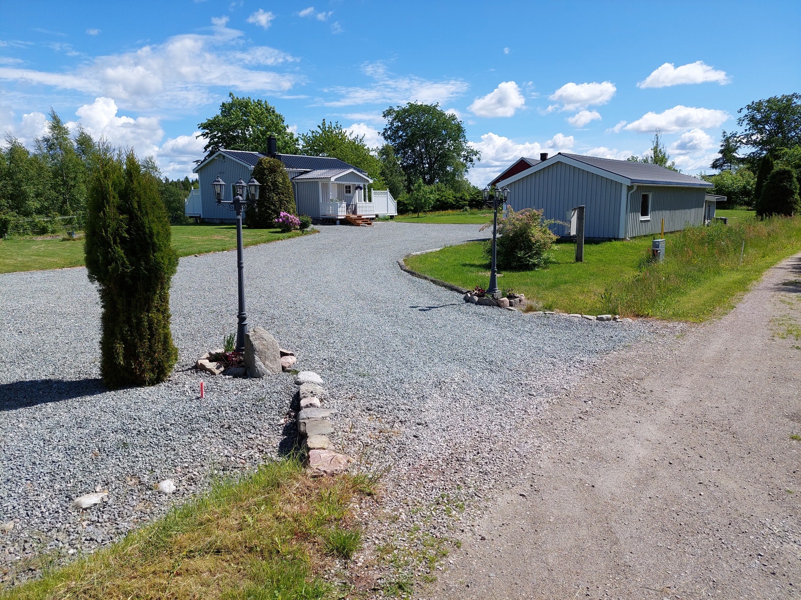 Innkjørsel med fine lykter og beplantning ønsker deg velkommen. Fin stor gårdsplass som ble påkostet et tykt lag med singel i 2019. Galleribilde