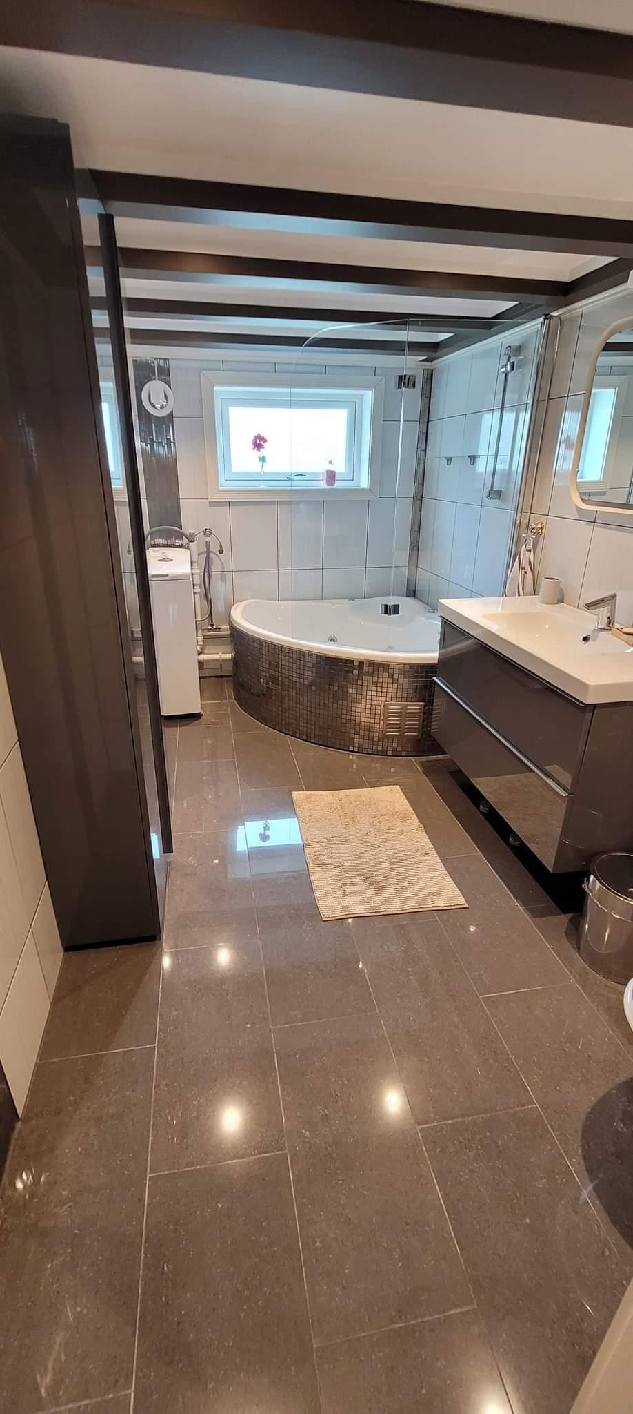 Badet er stort og flott med hjørnebadekar, dusj og vegghengt toalett. Spottene i taket kan også her dimmes. Galleribilde