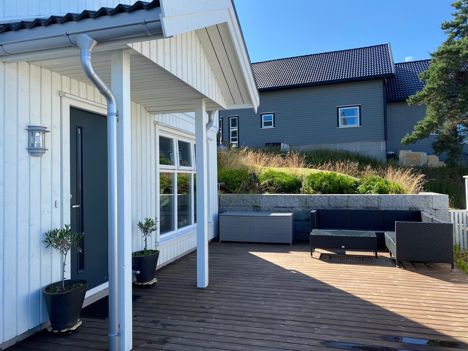 Inngangsparti med takoverbygg, og stor uteplass. Galleribilde