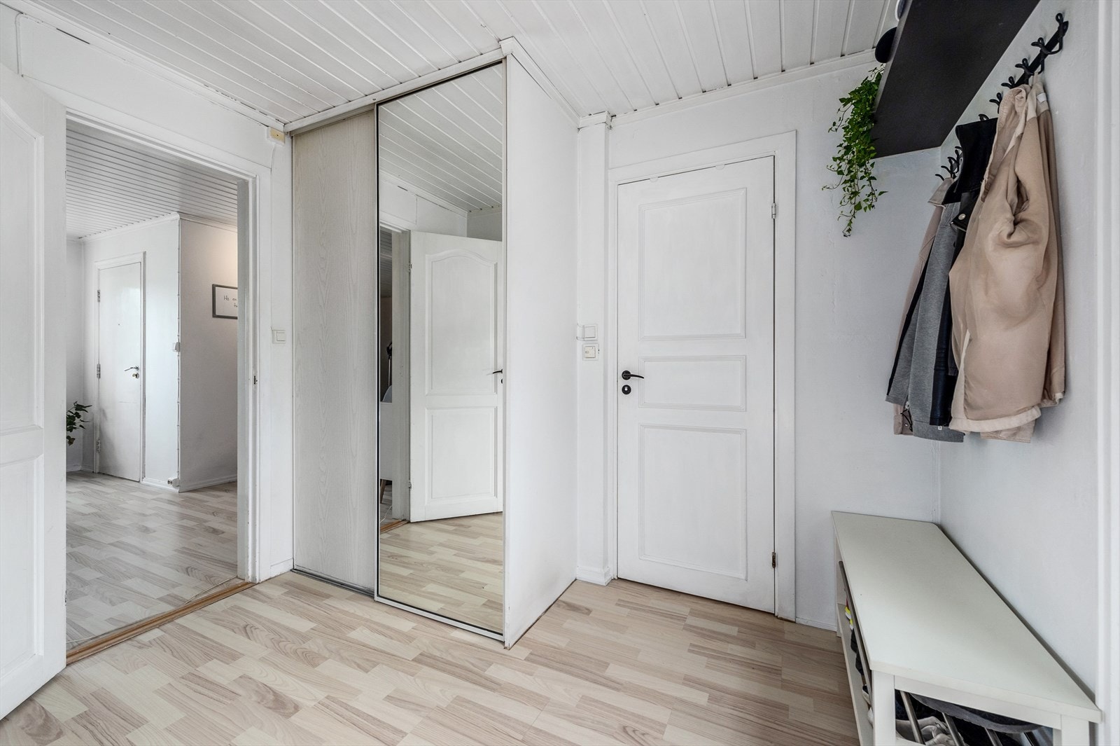 Inni leiligheten blir du møtt av en praktisk og luftig entré med laminat på gulvet og lyse overflater. Det er god plass til å henge fra seg og sette fra seg skoene i den plassbygde skyvedørsgarderoben. Galleribilde