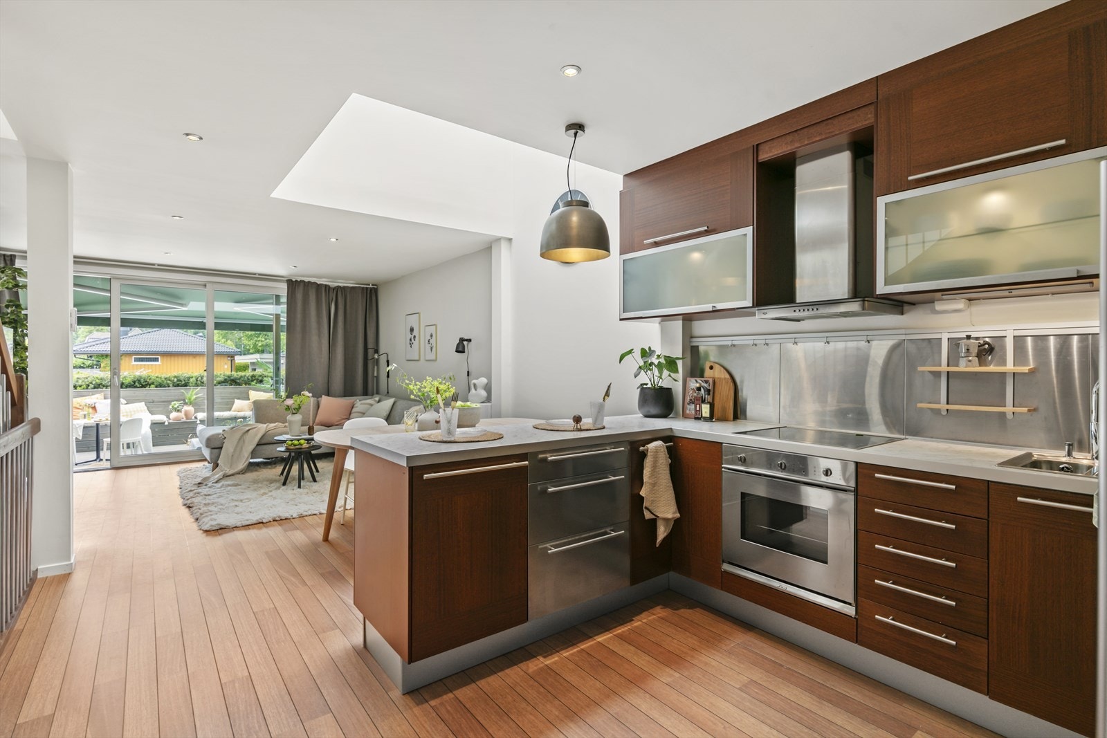 Lys i overskap, kroker/ heng på vegg-stålplater. Halvøya deler fint av mot spisegruppen Galleribilde