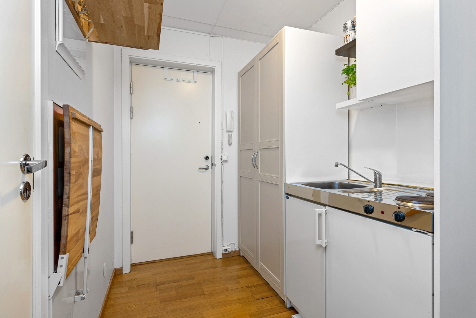 Kjøkkenet i utleiedel har benkebeslag i stål med oppvaskkum og to kokeplater, og under er det skap og integrert kjøleskap. Galleribilde