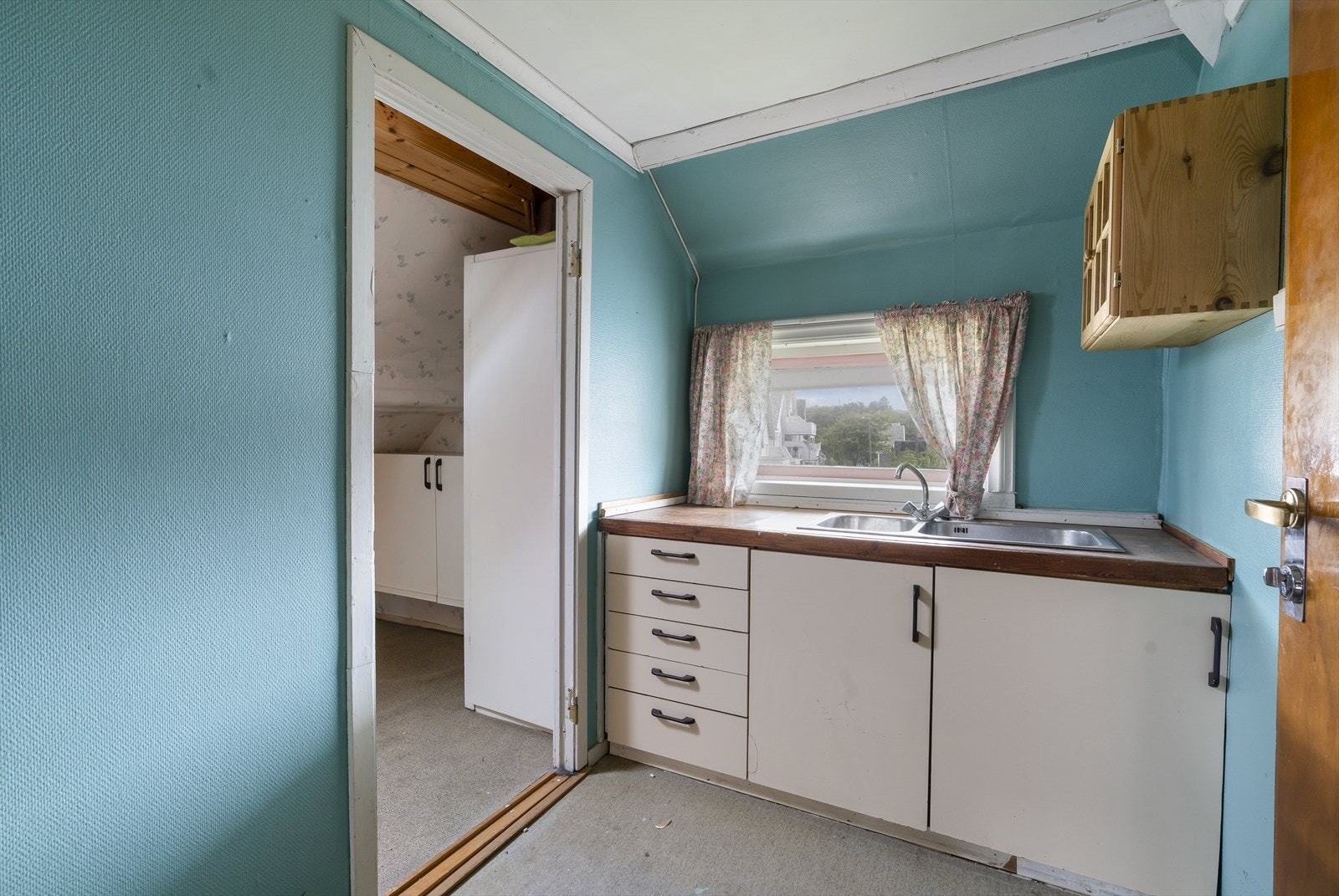 Kjøkken på loft. Loftet består av flere rom og eldre kjøkkeninnredning uten hvitevarer. Frontene er glatte og benkeplate i laminat hele etasjen her må renoveres hvis den skal opp til dagens standard Galleribilde