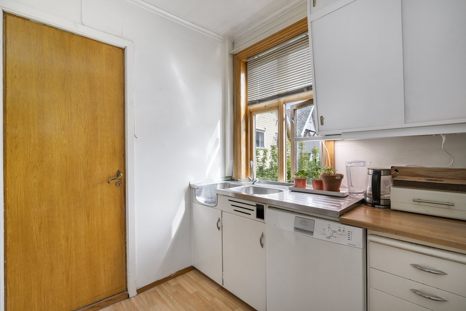 Kjøkkenet i leiligheten er innredet med glatte fronter, og eldre type skap, benkeplate av laminat. Galleribilde