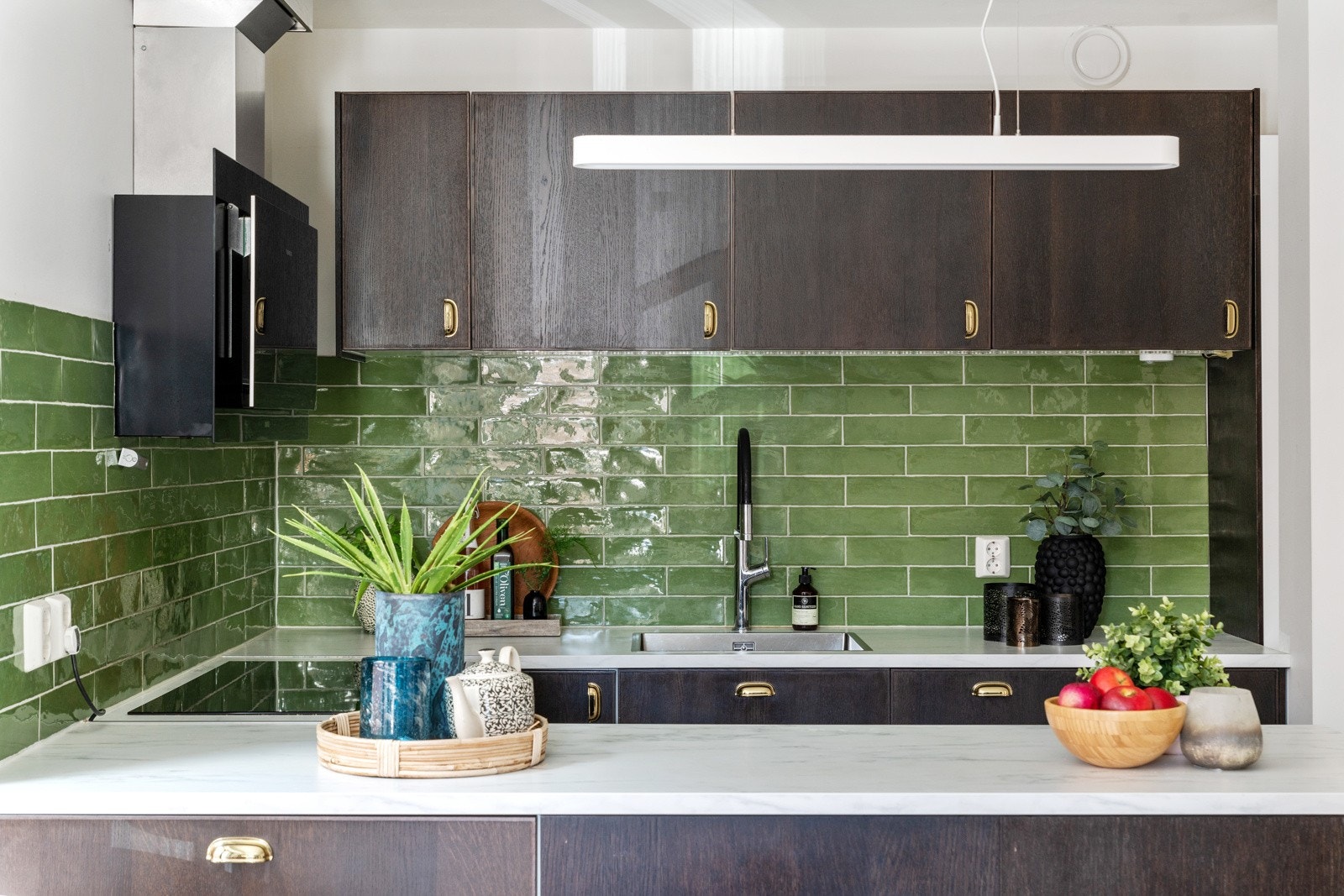 De integrerte hvitevarene som induksjonstopp, stekeovn og oppvaskmaskin medfølger handelen. Kjøleskap med frysedel er plassert i sone i stuen. Det er fliser på vegg over kjøkkenbenker, benkeskapbelysning og stikkontakter. Galleribilde