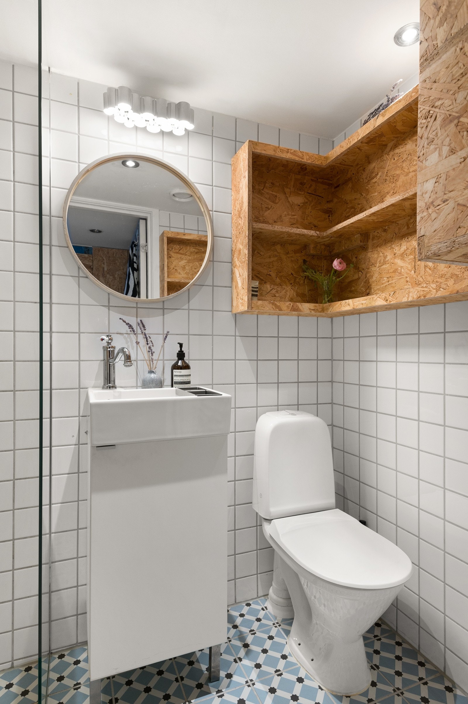 Pen heldekkende servant med underskap. Vegghengt speil. Romslig dusjhjørne med nedsunket gulv og veggmontert dusjgarnityr på vegg og vegghengte dusjegger i herdet glass i sprutsone. Galleribilde