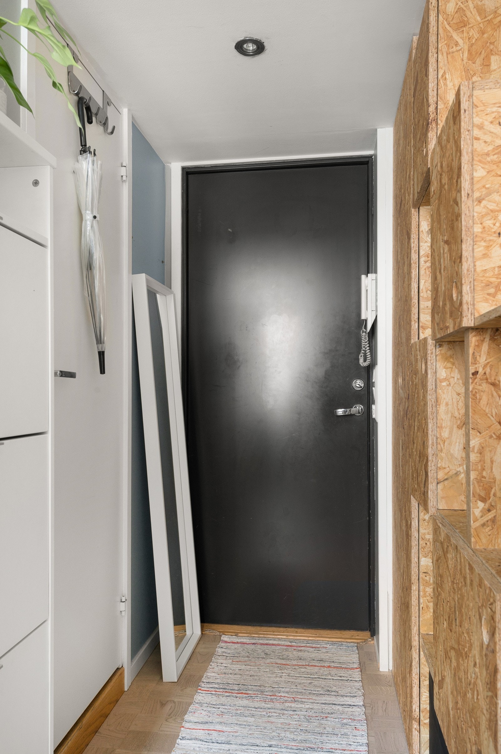 Malt brann- og lydklassifisert entrédør. Stiling rutemønstret eikeparkett på gulv, malte vegger og malt himling med downlights. Galleribilde