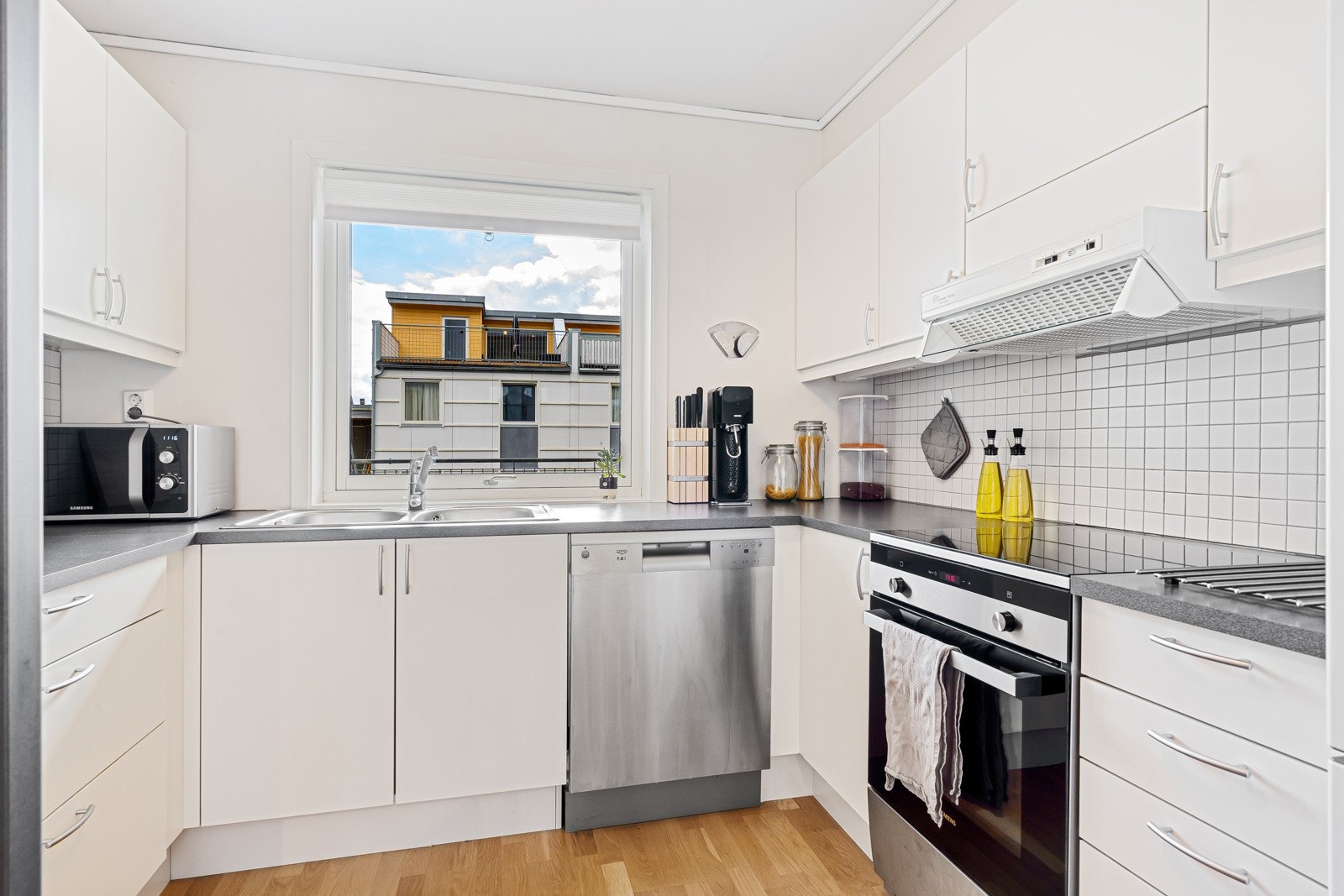 Kjøkkenet nyter en praktisk utforming for ekstra skap og benkeplass Galleribilde