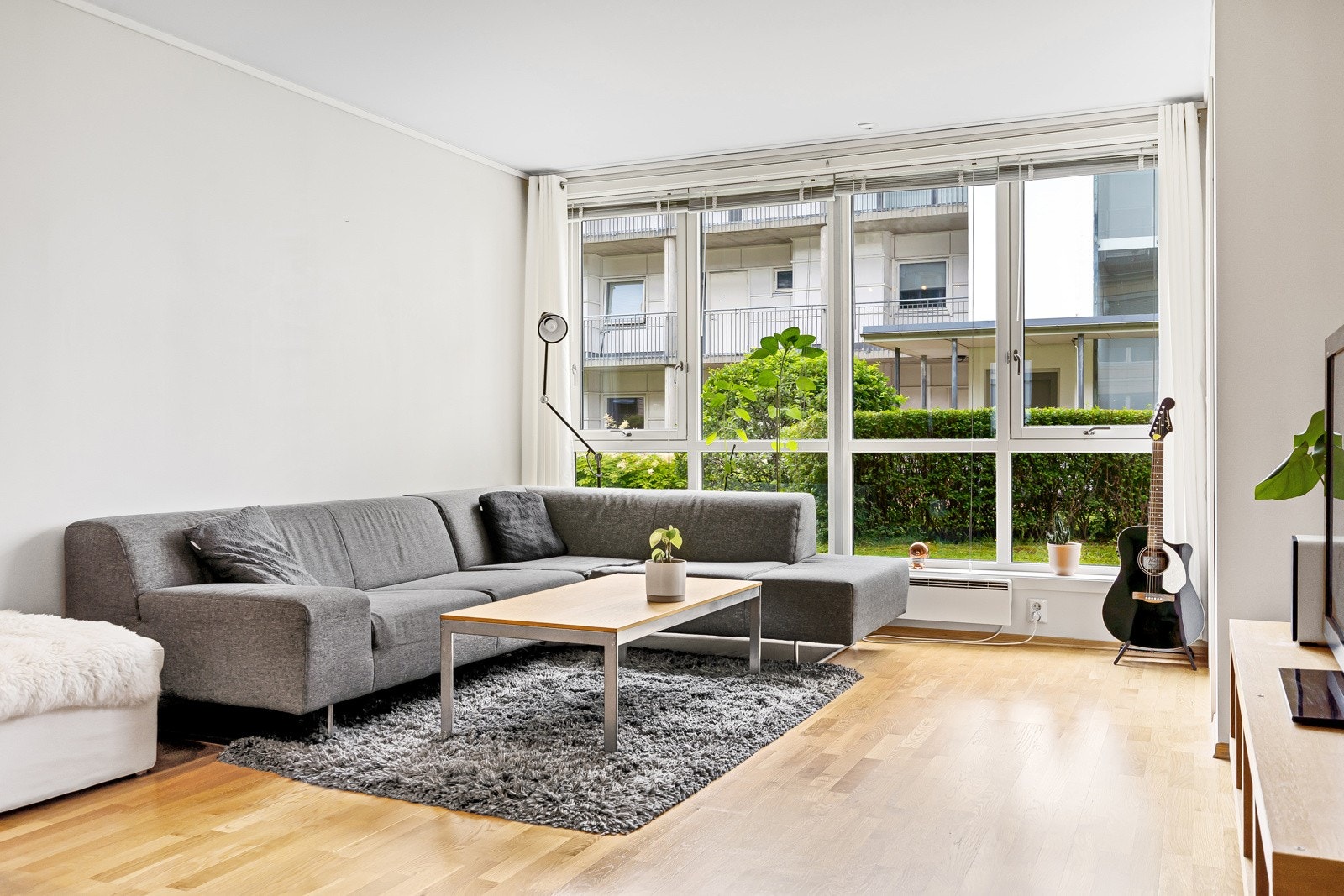 Store vindusflater kombinert med den generøse takhøyden setter et lyst og luftig preg på stuen Galleribilde