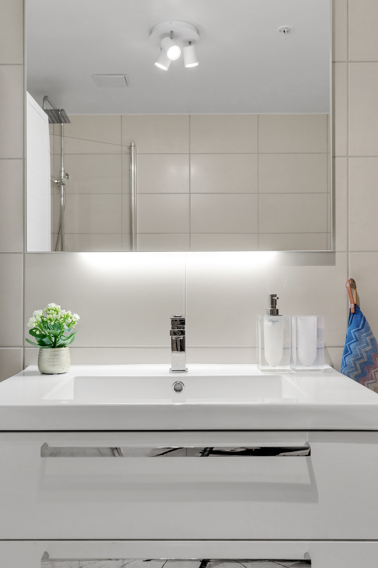 Badet er pent innredet med bl.a. servant og speilskap med belysning og dusjhjørne med svingbare glassdører. Galleribilde