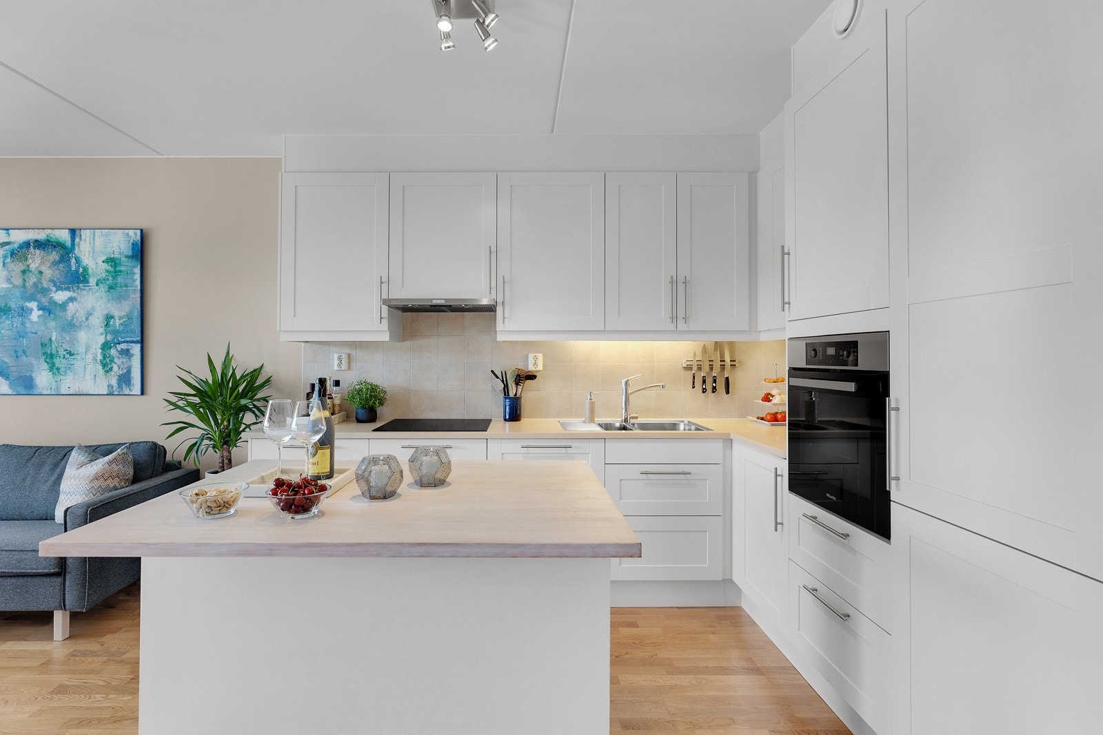 Praktisk kjøkkenøy som fungerer som boligens sosiale midtpunkt. Galleribilde