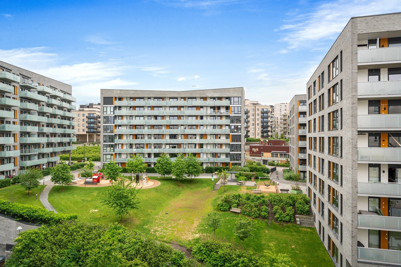 Pent opparbeidet uteområder med sitteplasser og lekeplass. Galleribilde