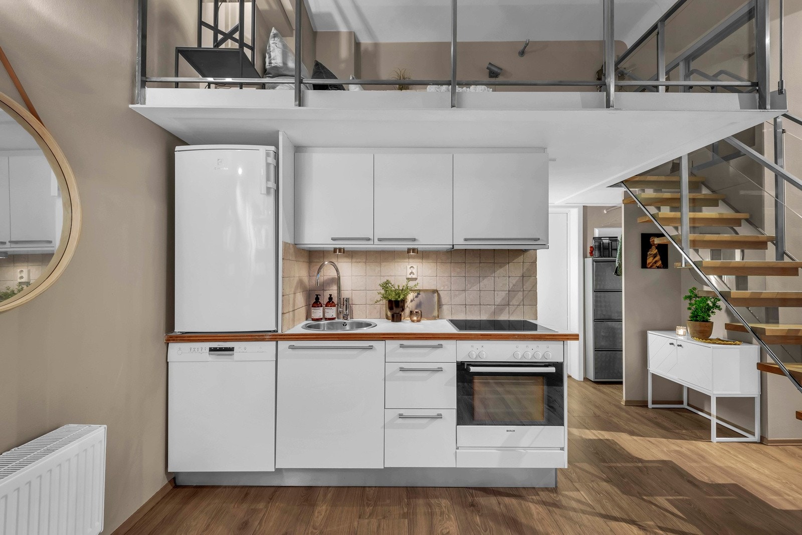 Kjøkkenet er arealeffektivt anlagt mot badet. Kjøkkenet har integrert platetopp og stekeovn, oppvaskmaskin, ventilator over kokesone og kjøleskap Galleribilde