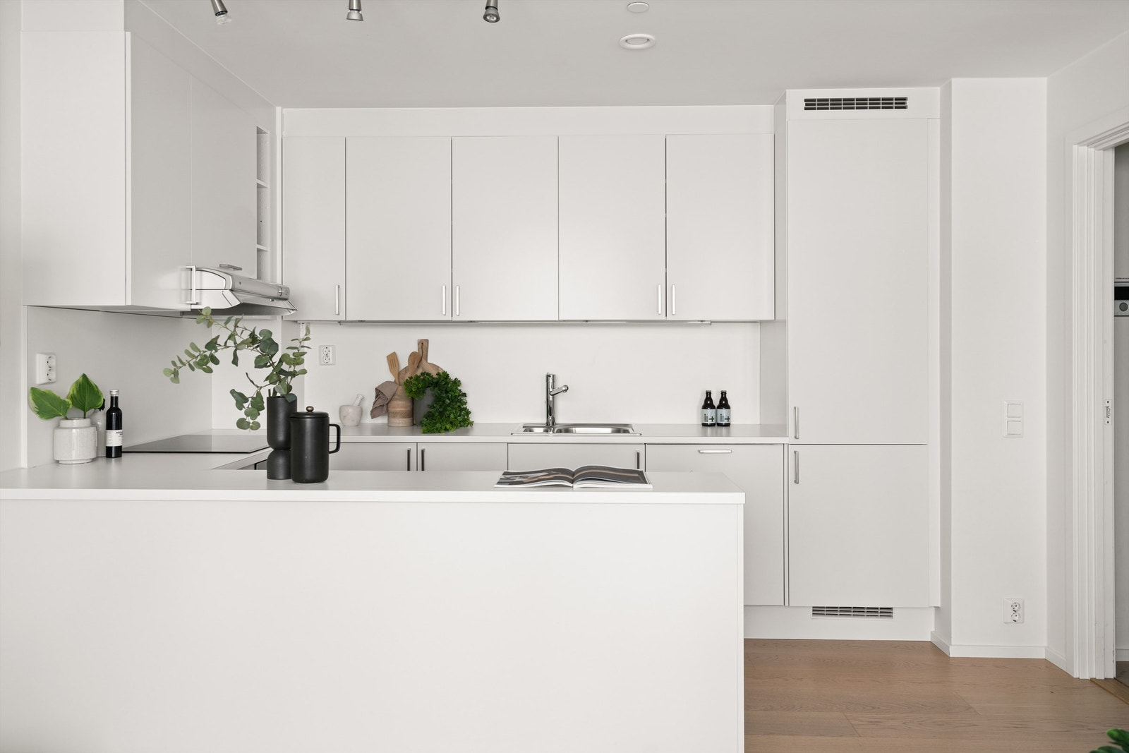 Praktisk barløsning på kjøkken som skaper et naturlig skille mellom stue og kjøkken Galleribilde