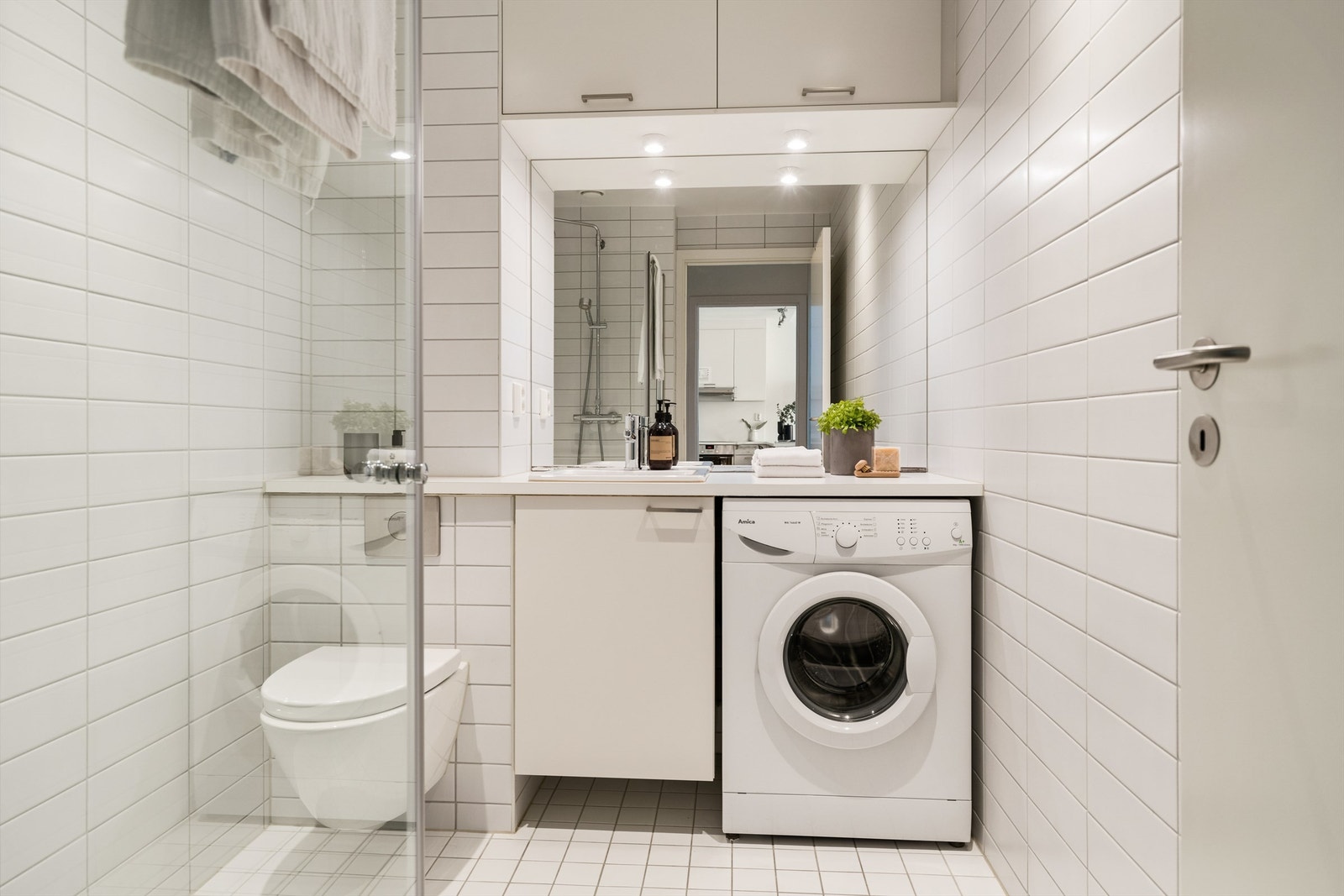 Pent flislagt baderom. Badet inneholder avsatt plass til vaskemaskin, WC og dusjhjørne. Galleribilde